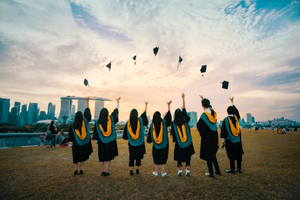 Graduates celebrating by throwing their caps in the air